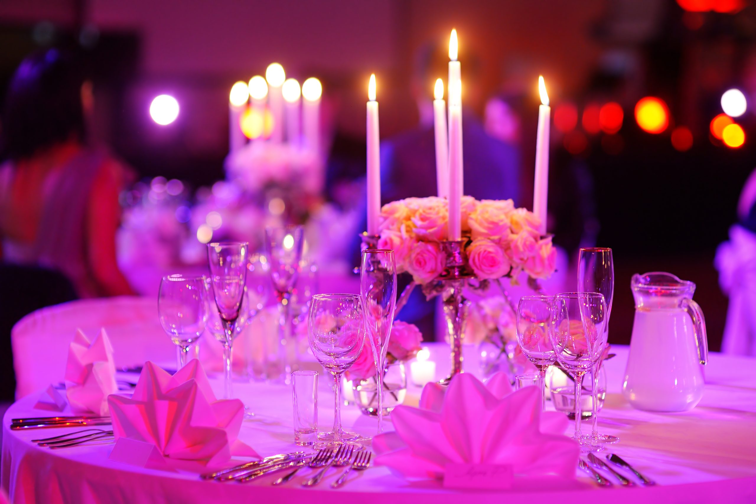 Table set for an event party or wedding reception in purple light