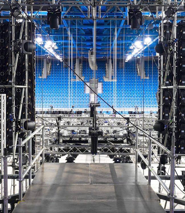 Installation of equipment and spotlights for stage. Stock footage. Preparing stage with bleachers and professional equipment and floodlights before performance or competition.