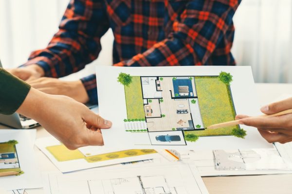 Professional architect engineer team discussion about green design of eco house at green business team meeting. Closeup. Environmental protection and green engineering. Focus on hand. Delineation.