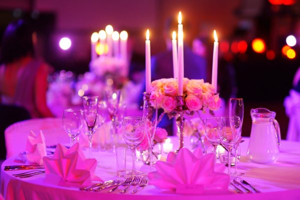 Table set for an event party or wedding reception in purple light